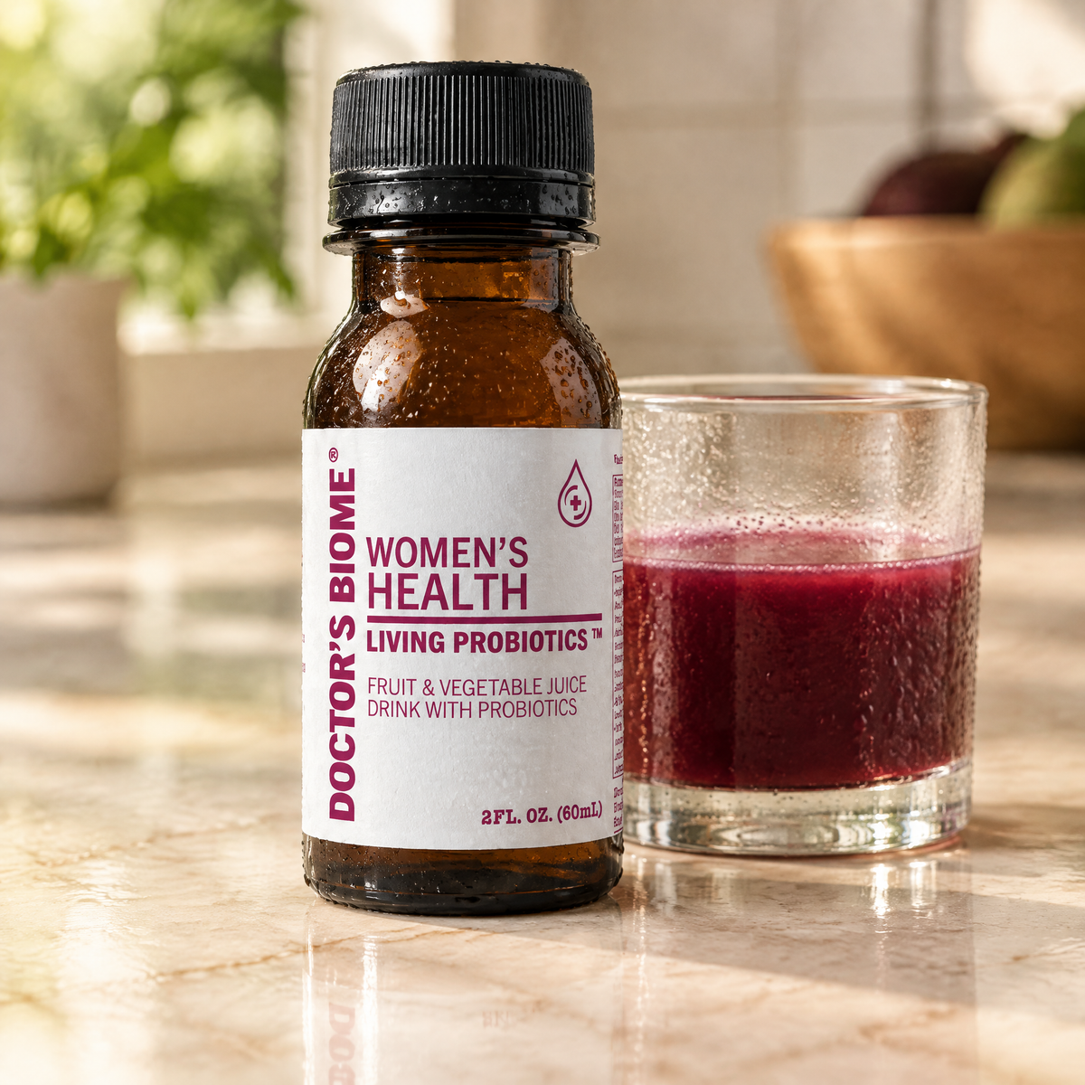 A bottle of Doctor’s Biome Women’s Health beside a glass of poured red juice.